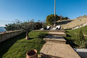 a walkway with two benches on a grassy field at Agriturismo Umbrian Sunrise in Cannara