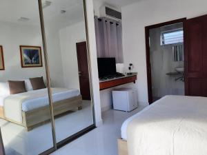 a hotel room with a large mirror and a bed at Hotel Plein Soleil in Grand Anse