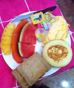 a plate of breakfast food with eggs fruit and toast at Lanta Fa Rung Beach Resort in Ko Lanta
