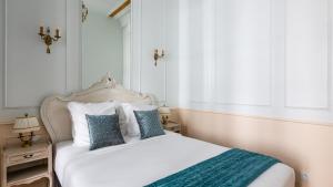 a bedroom with a white bed with blue pillows at Luxury 3 Bedroom 2 Bathroom - AC - Louvre & Marais in Paris