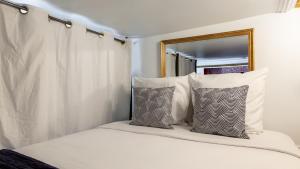 a white bed with two pillows and a mirror at Luxury 3 Bedroom 2 Bathroom - AC - Louvre & Marais in Paris