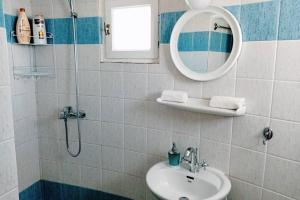 a bathroom with a sink and a mirror and a shower at Casetta Annaise Mykonos-Myconian House for two in Mikonos