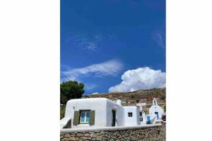 a white house on a hill with a blue sky at Casetta Annaise Mykonos-Myconian House for two in Mýkonos City