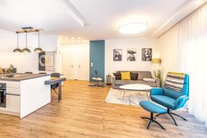 uma cozinha e sala de estar com uma cadeira azul em VIVA Apartments em Graz