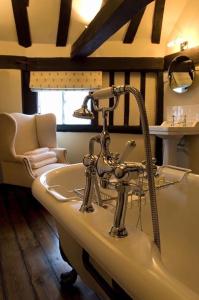 a bathroom with a bath tub and a sink at The Crown Inn in Chiddingfold