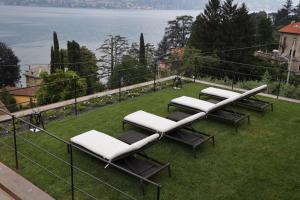 una fila de tumbonas sentadas sobre un césped en Villa Mojana Bellagio en Oliveto Lario