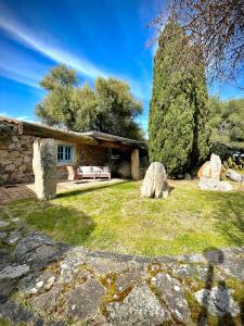 uma casa de pedra com um jardim em frente em Punta D'Acu Country Resort em Arzachena