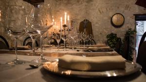 a table with wine glasses and a plate with a napkin at LA MORA Exclusive in Moricone +17 photos