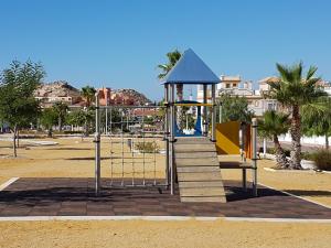 um parque infantil num parque com um portão e árvores em AS017 Castillo 3-Bedroom San Juan de Los Terreros em San Juan de los Terreros