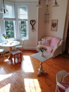 a living room with a pink couch and a table at Furain in Peterculter