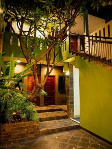 un edificio con un árbol delante de una puerta roja en Rhiz Guest House Tebet en Yakarta