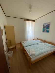 ein Schlafzimmer mit einem Bett und einem Stuhl darin in der Unterkunft Hotel Bellavista Cavigliano in Cavigliano