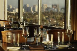 a table with wine glasses and a view of a city at Hotel Angeleno in Los Angeles