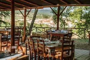 a restaurant with wooden tables and chairs on a deck at Agriturismo Poggio Di Sotto in Galliano
