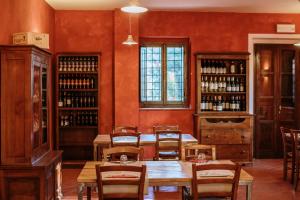 a dining room with a table and chairs and wine bottles at Agriturismo Poggio Di Sotto in Galliano