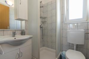 a bathroom with a sink and a toilet and a shower at Apartments Spirit of the Sea in Tkon