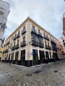 a large white building with balconies on a street at piso exterior centro sevilla in Seville