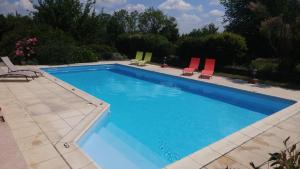 une piscine avec deux chaises et une piscine dans l'établissement Ânes Et Logis, à Bax