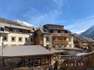 a group of buildings with mountains in the background at Hôtel Restaurant & Spa Les Autanes in Ancelle