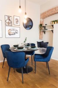 a dining room with a table and blue chairs at Garden Oasis in Zagreb