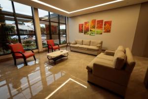 a living room filled with furniture and a large window at Hotel Pousada da Serra in Maracaju