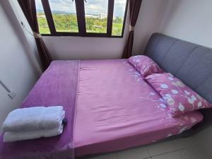 a bed with a purple sheets and a window at Maz Stayhouse in Alor Setar