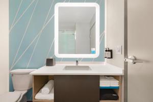 uma casa de banho com um lavatório e um espelho em avid hotels - Melbourne - Viera, an IHG Hotel em Melbourne
