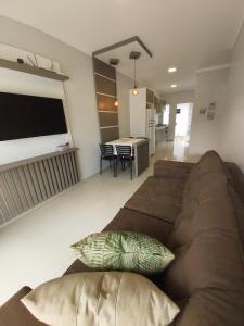 sala de estar con sofá marrón y mesa en Curta Praia de Armação - Casa Girassol, en Penha