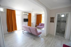 a living room with a pink chair and a bathroom at Paradise Hotel in Kemer