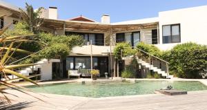 a house with a swimming pool in front of a building at Posada del Faro in José Ignacio