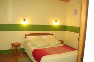 a bedroom with a bed with green and white stripes at Gites de la Filaterie in Cormatin