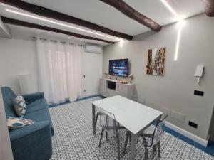 uma sala de estar com um sofá azul e uma mesa em Chiaja Lux House em Nápoles
