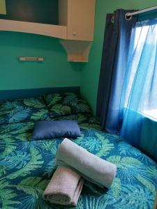 Una cama con dos almohadas y una toalla. en Le pré vert, en Campigny