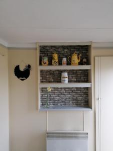 a shelf with pots and pans on a wall at Le pré vert in Campigny