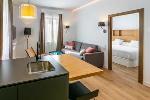 a room with a kitchen and a living room at Aquitania Home Suites in Seville