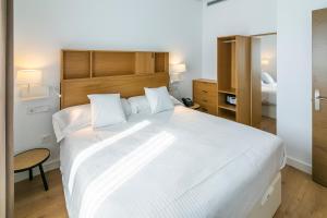 Postel nebo postele na pokoji v ubytování Aquitania Home Suites