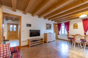 sala de estar con mesa y TV en Appartamento Vernelia Val di Fassa Sella Ronda en Campitello di Fassa