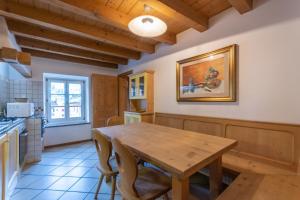 una cucina con tavolo e sedie in legno di Appartamento Vernelia Val di Fassa Sella Ronda a Campitello di Fassa