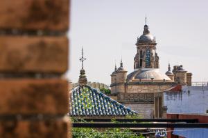 un edificio con una torre de reloj en el fondo en Aquitania Home Suites, en Sevilla