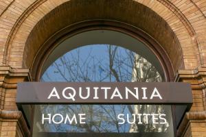 einem Bogenfenster eines Gebäudes mit einem Schild in der Unterkunft Aquitania Home Suites in Sevilla