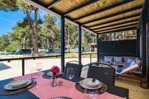 a table with wine glasses and flowers on a patio at Perla - Lux Mobile Homes in Rovinj