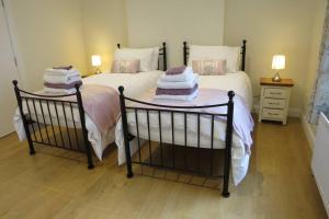 a bedroom with two beds and a table with towels at Jenny's Farm Cottage, Giant's Causeway in Dunseverick