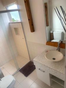 a bathroom with a shower and a sink and a toilet at Estaleiro Casa Hotel in Balneário Camboriú