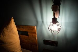 a lamp hanging from a wall next to a bed at East BOX 40A - Ferienhaus in Modern Art in Bautzen