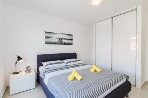 a bedroom with a bed with yellow pillows at Ilicevic Kralja Zvonimira in Crikvenica