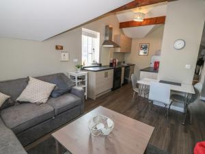 a living room and kitchen with a couch and a table at Tan Bryn 1 in Aberdaron