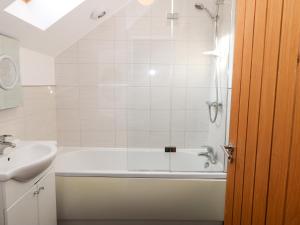 a bathroom with a bath tub and a sink at Tan Bryn 1 in Aberdaron +6 photos