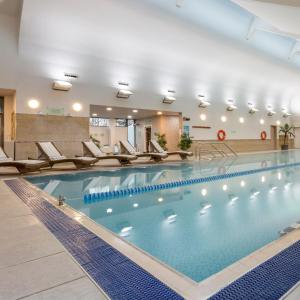 - une grande piscine avec des chaises dans un bâtiment dans l'établissement Ashford International Hotel & Spa, à Ashford