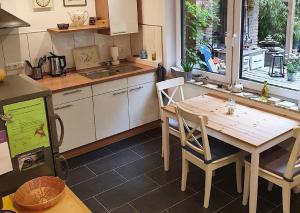 a kitchen with a wooden table and chairs and a window at Ferienwohnung am Atelier Horn in Overath