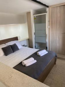 a bedroom with a large bed with two towels on it at Modern City Center Appartment Saripolou in Limassol